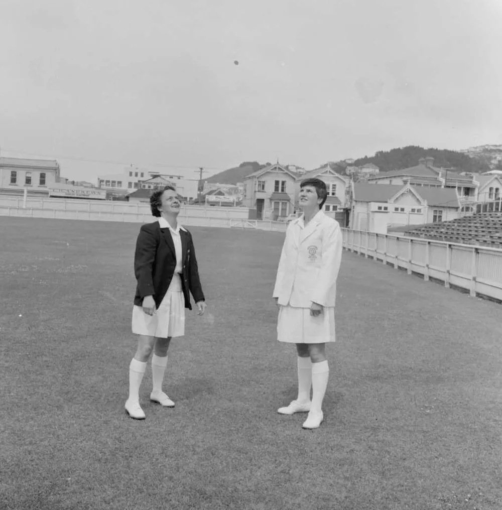 Two athletes tossing a coin on a sports field in 1957