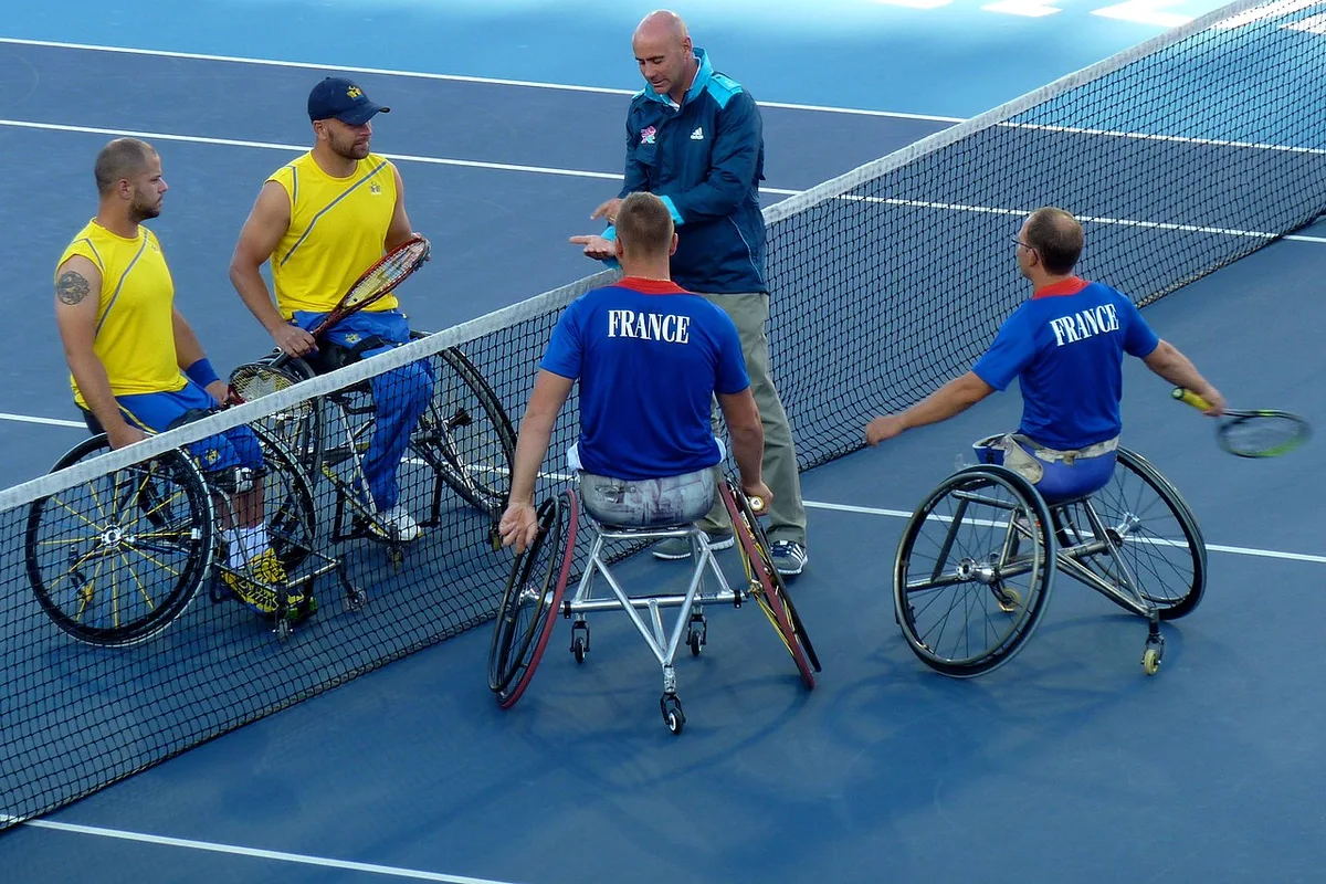 Wheelchair tennis players and an official during a coin toss at the net