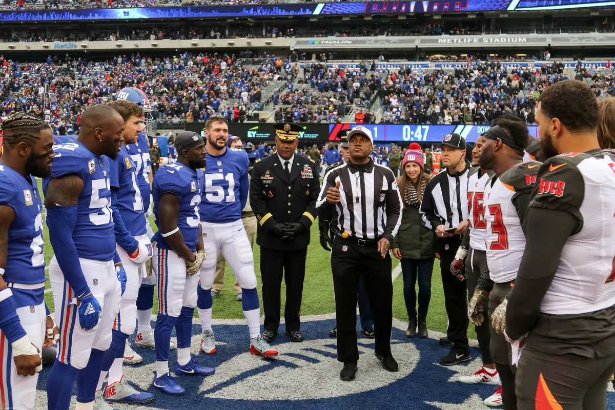 Football captains and officials gathering for a pre-game coin toss