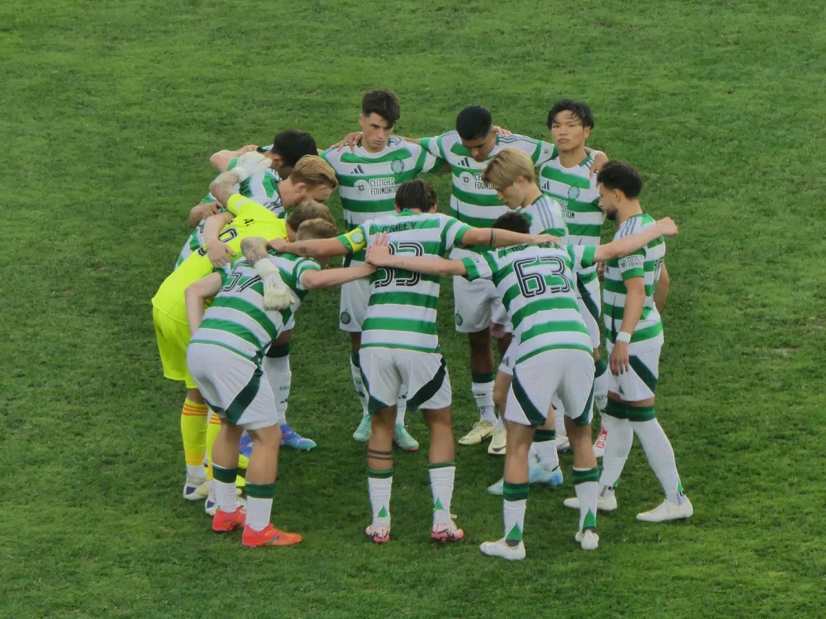 A soccer team huddling together on the field before play